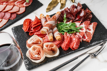Antipasto platter cold meat with grissini bread sticks, prosciutto, slices ham, beef jerky, salami...