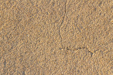 copyspace background texture beige wall of plaster with small colorful natural stones with a crack