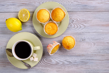 Fototapeta na wymiar Lemon muffins with coffee on a white wooden table