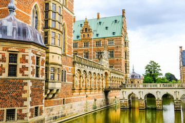 Frederiksborg castle or palace: Castle entrance with bridge and moat with water. Hillerod, Denmark.