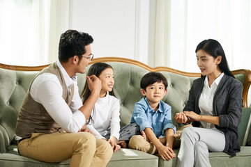 asian parents and two children chatting at home