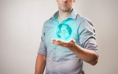 Casualy dressed businessman holding virtual projection of the world in his hand
