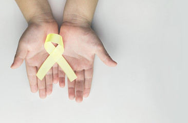 child holding gold ribbon. Cancer awareness