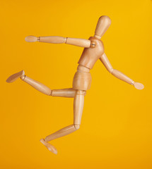 Wooden doll in kick ball pose