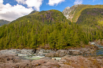 Fototapeta na wymiar Kennedy River and mountain range with forest landscape in Vancouver Island