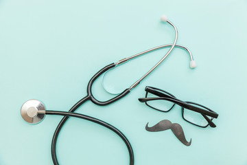 Man health care concept. Simply minimal design with medicine equipment stethoscope or phonendoscope glasses sign of mustache isolated on trendy pastel blue background. Doctor urologist