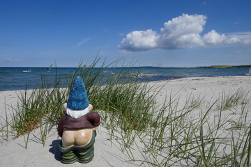 Holidays by the sea ... Dunes, white sandy beach and a little garden gnome with bare bottom (not...