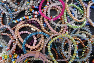 Many, colorful necklaces and bracelets made of glass beads