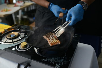 Making dinner at restaurant. Proffesional cooker