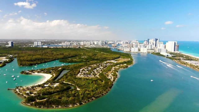 Drone rising over beautiful state park in Miami. You can see North Miami beach in the background and the bay in between.