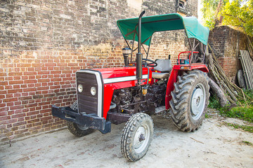 Red indian farming Tractor used for land, sowing, cultivator Transportation, background....