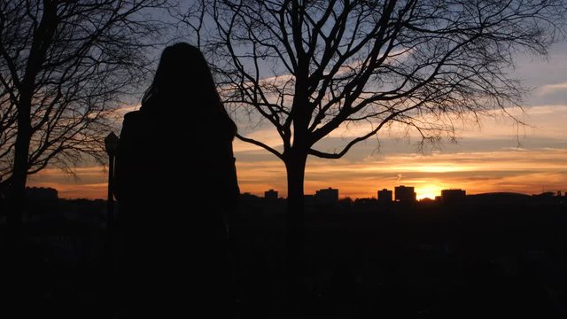 Beautiful silhouette shot in slow motion of a girl watching the sunset, in Porto, Portugal.