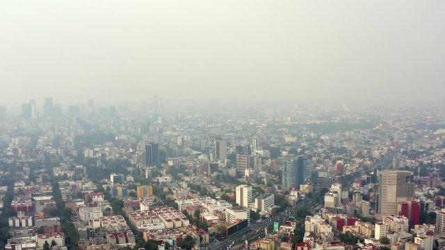 Aerial wide shot of the skyline of Mexico City in a very polluted day