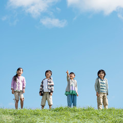 草原で空を見上げる小学生