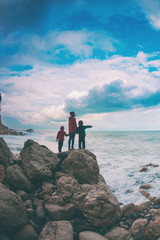 Silhouette of a woman and a children against the sea and sky.