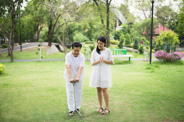 Elderly asian female exercise do physical with stick at park,Caretaker take care and support,Physical therapy