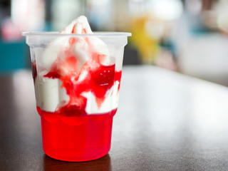 Ice cream with strawberry sauce and red jelly topping.