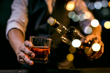 hand with glass of whiskey and cigar