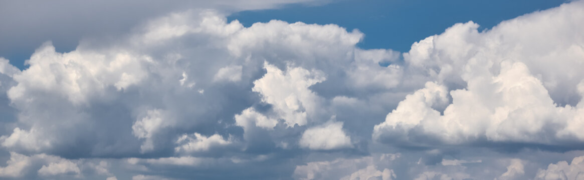 Panoramic view on Sky with dramatic clouds. Fluffy white clouds on the sky suitable for background. Cloudy sky. Overcast