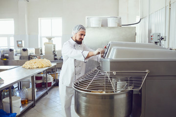 A baker makes the dough on the equipment in the bakery