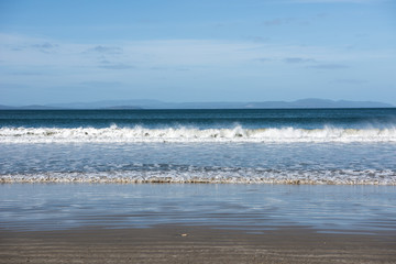 Fototapeta na wymiar Waves at Five Mile beach, Tasmania