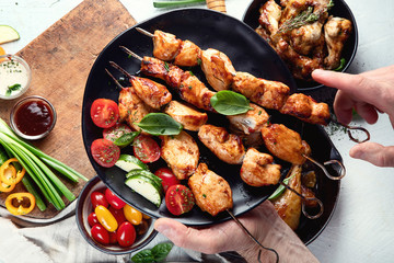 Man holding  kebabs on skewers