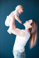 Mom raising infant girl offspring with her arms artistic photograph