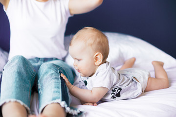 Newborn girl daughter touching mom's jeans dreamy artistic photograph