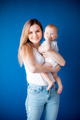 Smiling proud mom with infant newborn girl posing on camera artistic stunning portrait picture