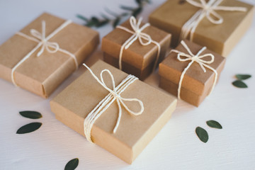 Craft gift boxes on white wooden background.