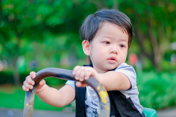 Cute little  Asian boy having fun on a playground outdoors , Happy kids