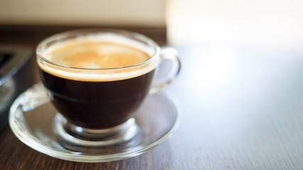 Fototapeta premium Cup of fresh brewed coffee near the coffee machine