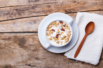 Muesli with yoghurt in white bowl. Healthy fitness breakfast background