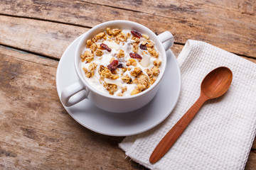 Muesli with yoghurt in white bowl. Healthy fitness breakfast background