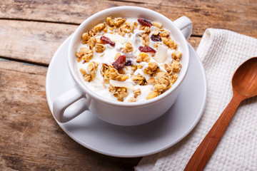 Muesli with yoghurt in white bowl. Healthy fitness breakfast background