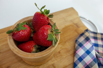 bowl of strawberries on chopping board