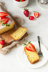 Pound or loaf cake with strawberry and mint on wooden board. Delicious summer dessert.