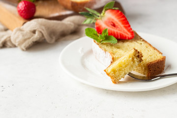 Pound or loaf cake with strawberry and mint on wooden board. Delicious summer dessert.