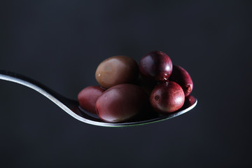 A spoon full of black olives