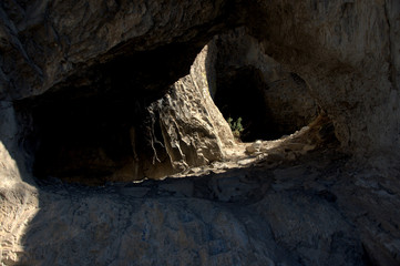 Small through cave in the mountain range. Altai, Siberia, Russia. Landscape.