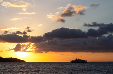 Fototapeta na wymiar passenger ship that sails in a bright yellow sunset near the Istanbul Islands
