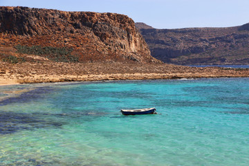 Plakat Sea view with clear turquoise water and empty boat, Crete island, Greece