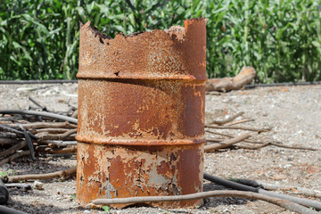 rusty orange metal barrel, old barrel and damaged by moisture and sun