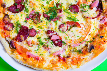hot tasty fresh pizza on a plate close-up. green background