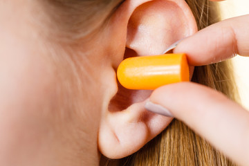 Woman putting earplugs
