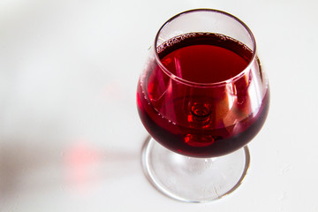 Glass with red wine on a white background