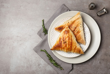 Plate with delicious samosas on grey background