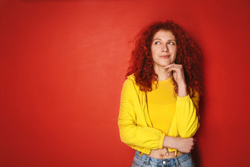 Thoughtful redhead woman on color background