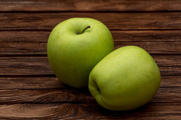 Green apples on dark brown wooden background. Summer fruits. Natural vitamins. Healthy food.