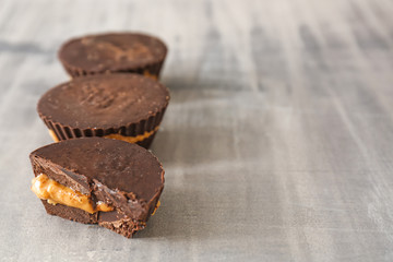 Tasty chocolate peanut butter cups on grey table